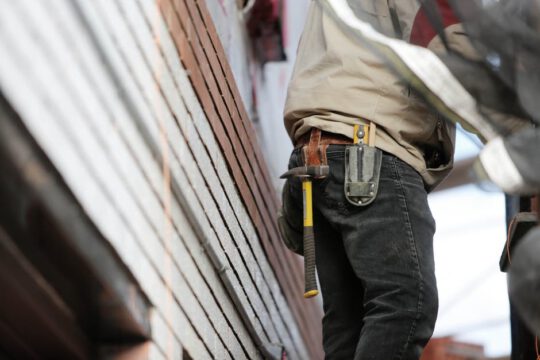 Construction worker with hammer on toolbelt | SLM Facilities