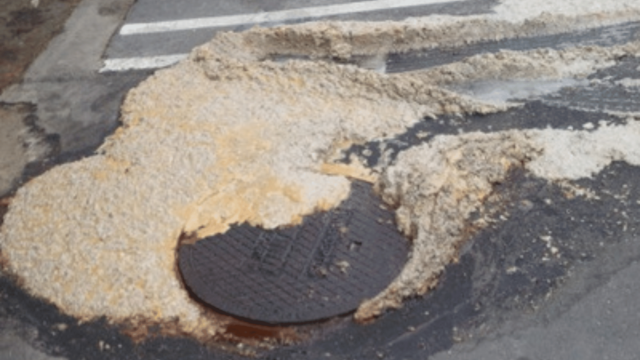 Grease Trap Best Practices for Kitchens blog image showing an overflowing exterior grease trap flowing into a parking lot