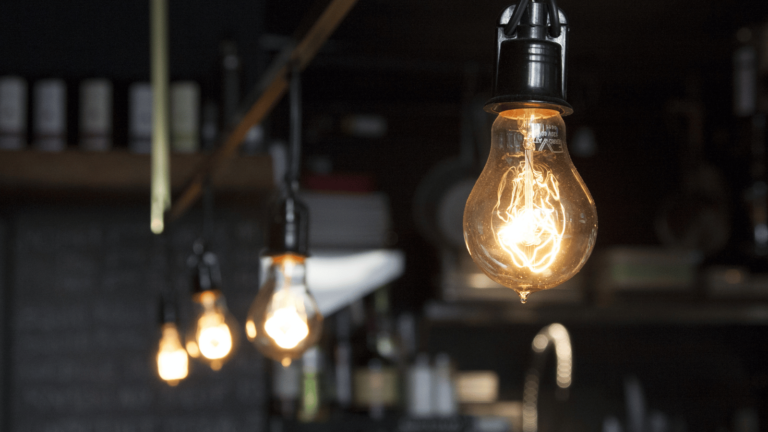 Edison style lightbulbs hanging from ceiling on a blurry background